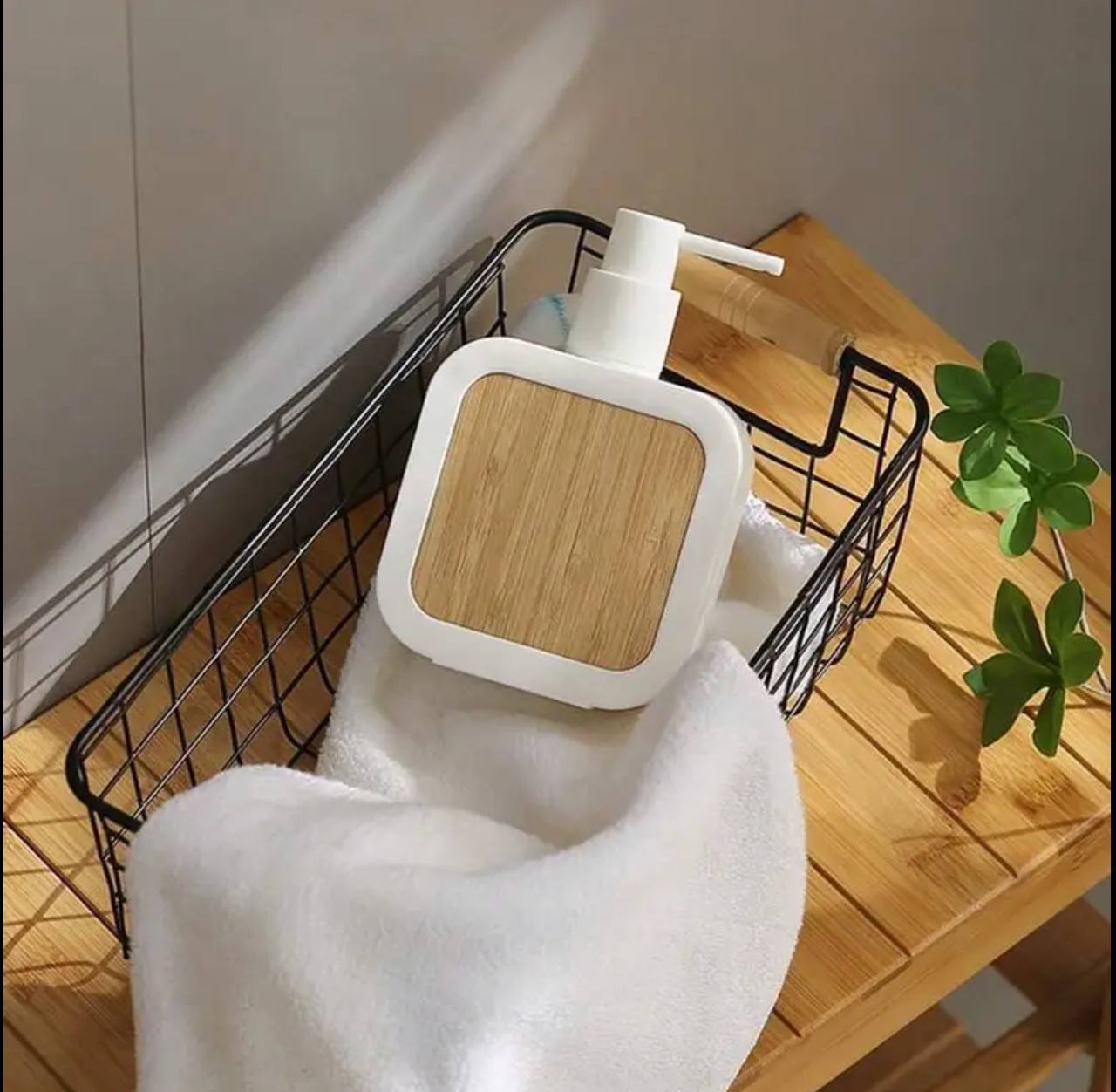 Square plastic soap dispenser with bamboo accent pump.