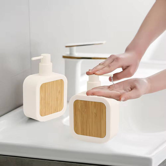 Square plastic soap dispenser with bamboo accent pump.