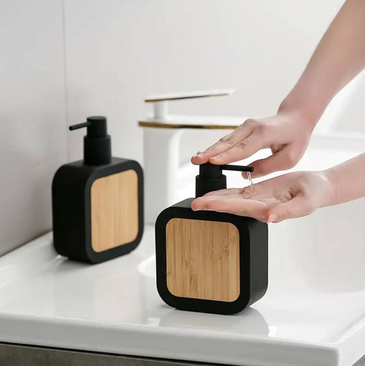 Square plastic soap dispenser with bamboo accent pump.